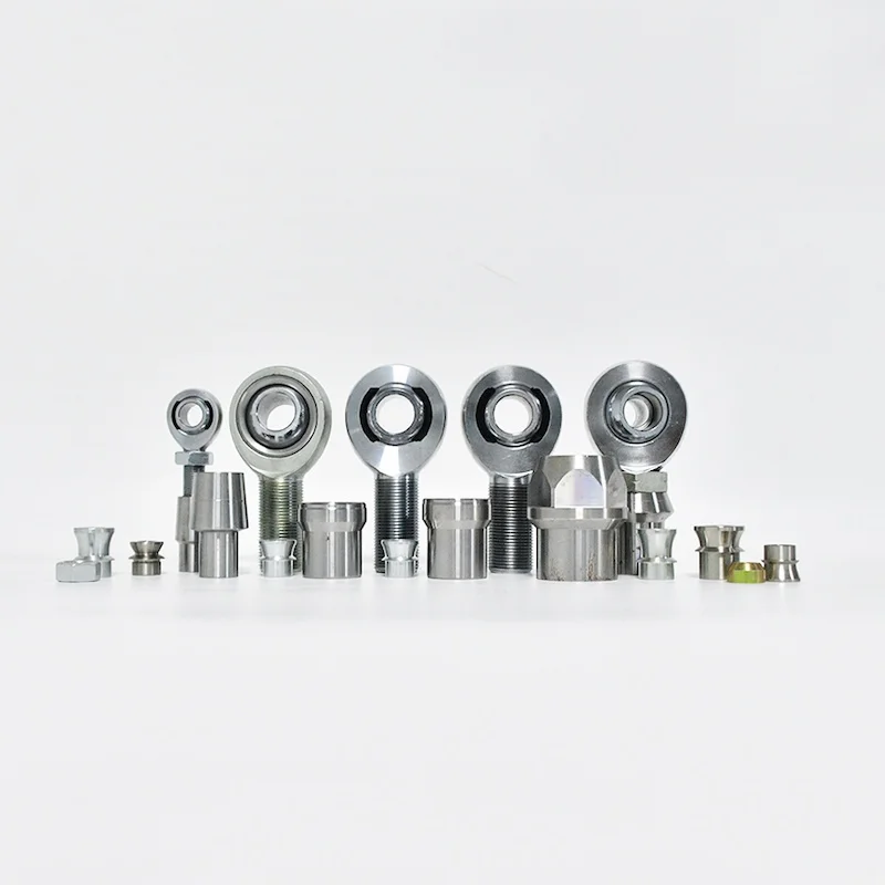 A collection of heim joints with accessories including tube adapters, jam nuts, spacers, and related components, arranged in a row.